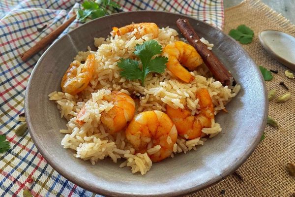 A bowl of rice with shrimp and spices.