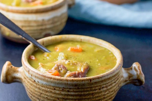 Two bowls of pea soup with a spoon.