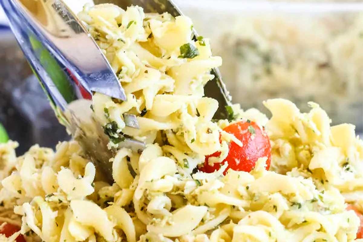 A fork is being used to scoop pasta salad out of a bowl.