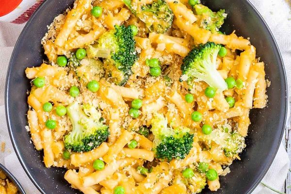 Pasta with broccoli and peas in a skillet.