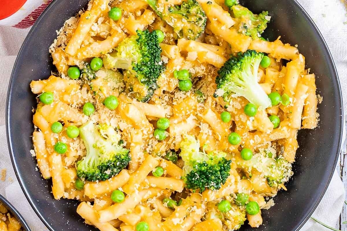 Pasta with broccoli and peas in a skillet.