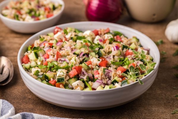 A colorful bowl of Greek salad with tomatoes and cucumbers.