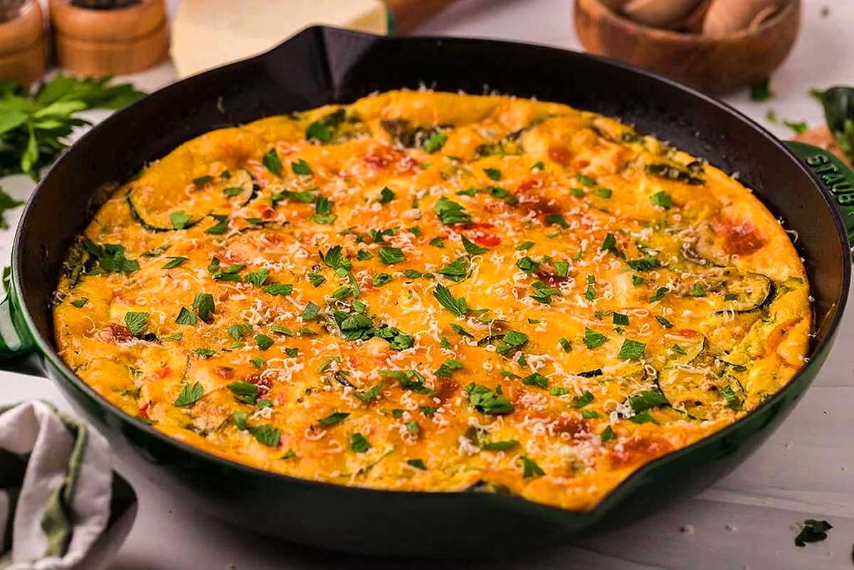 A skillet filled with a cheesy zucchini quiche.