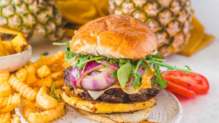 A pineapple burger on a plate with fries.