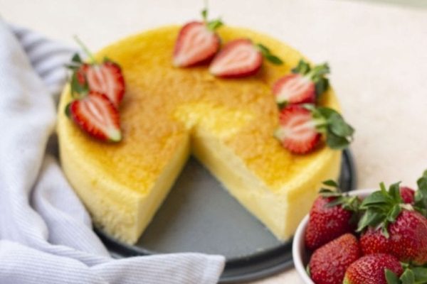 A slice of cheesecake with strawberries on a plate.