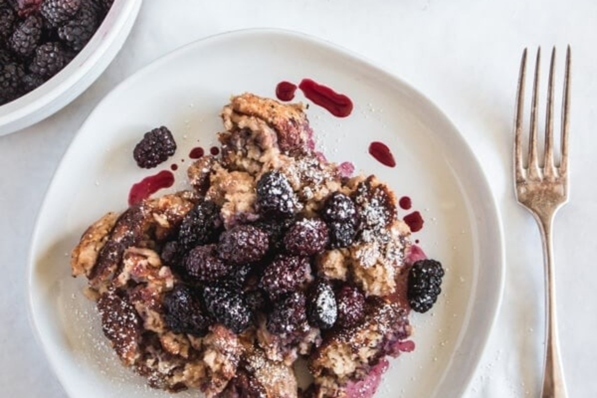 A scrumptious breakfast recipe for French toast served on a plate, enhanced with the sweetness of blackberries.