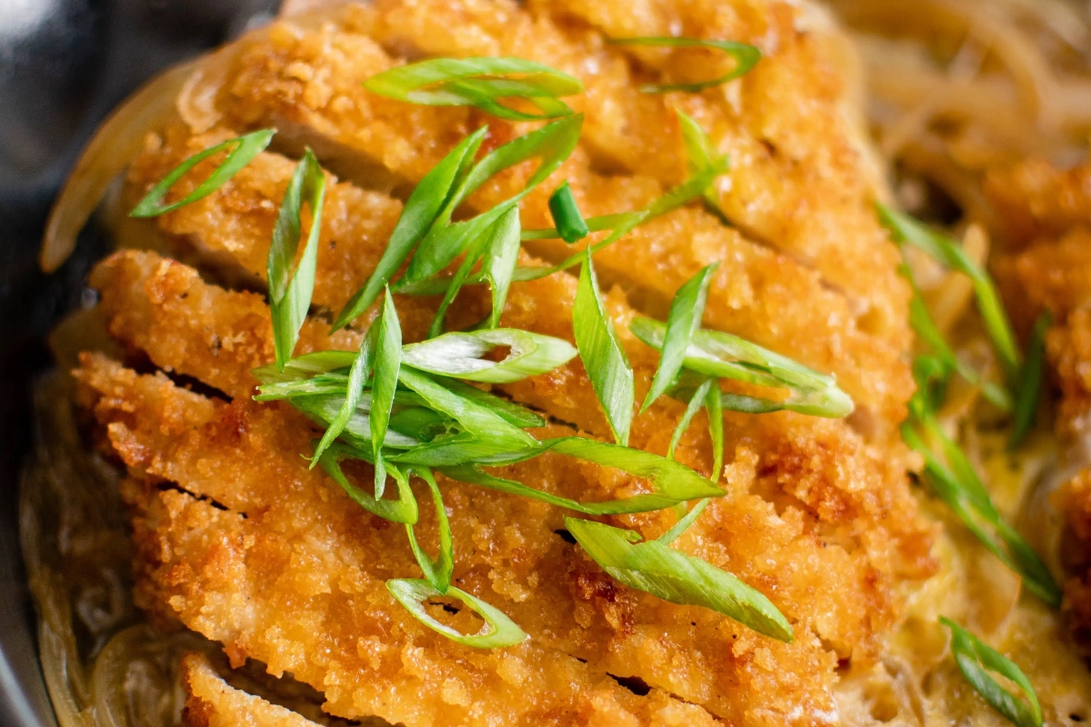 Fried chicken in a skillet with green onions is a perfect choice for dinner.
