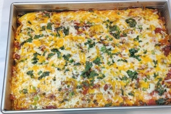 A casserole with cheese and spinach in a pan.