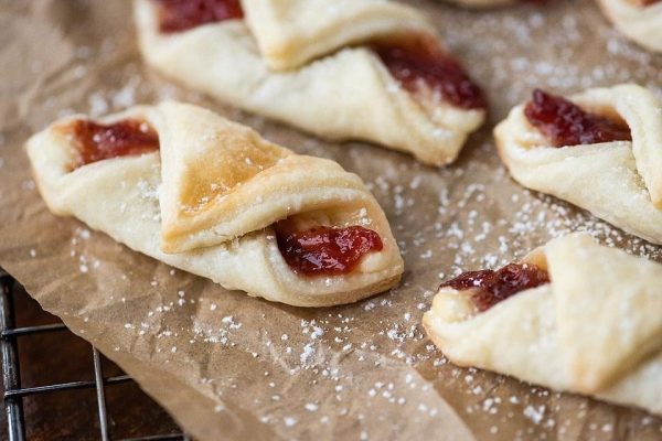A tray of Christmas pastries adorned with powdered sugar, perfect for gift giving.