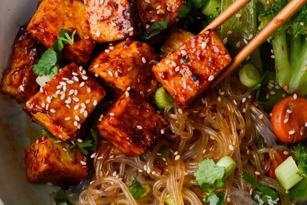 Budget-friendly tofu and broccoli bowl with chopsticks.