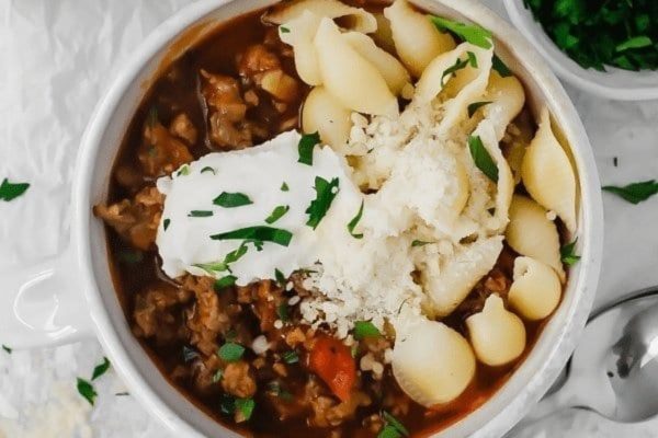 A bowl of pasta with meat and sour cream.
