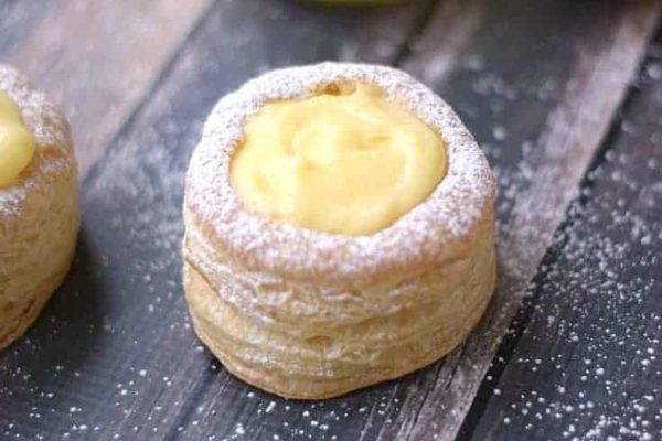 Two lemon tarts with powdered sugar on top.