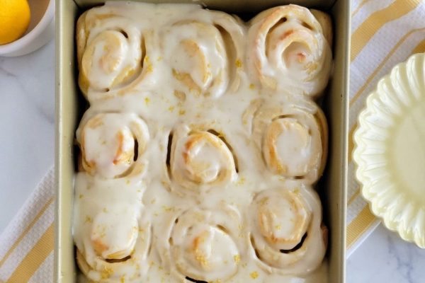 Lemon-infused cinnamon rolls baked in a pan.