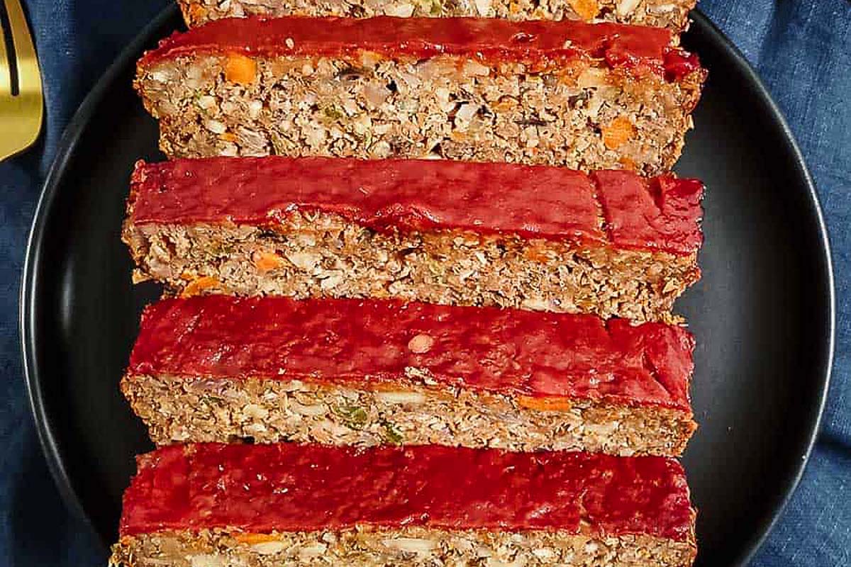 Sliced meatloaf on a plate with a fork, perfect for meatloaf recipes.