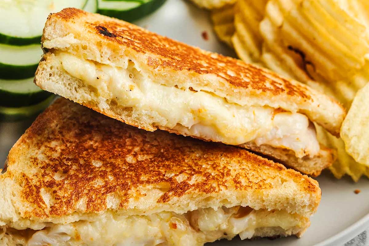 Grilled cheese sandwich and chips on a plate.