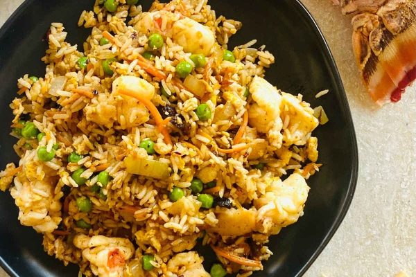 Asian fried rice with shrimp and peas on a plate.