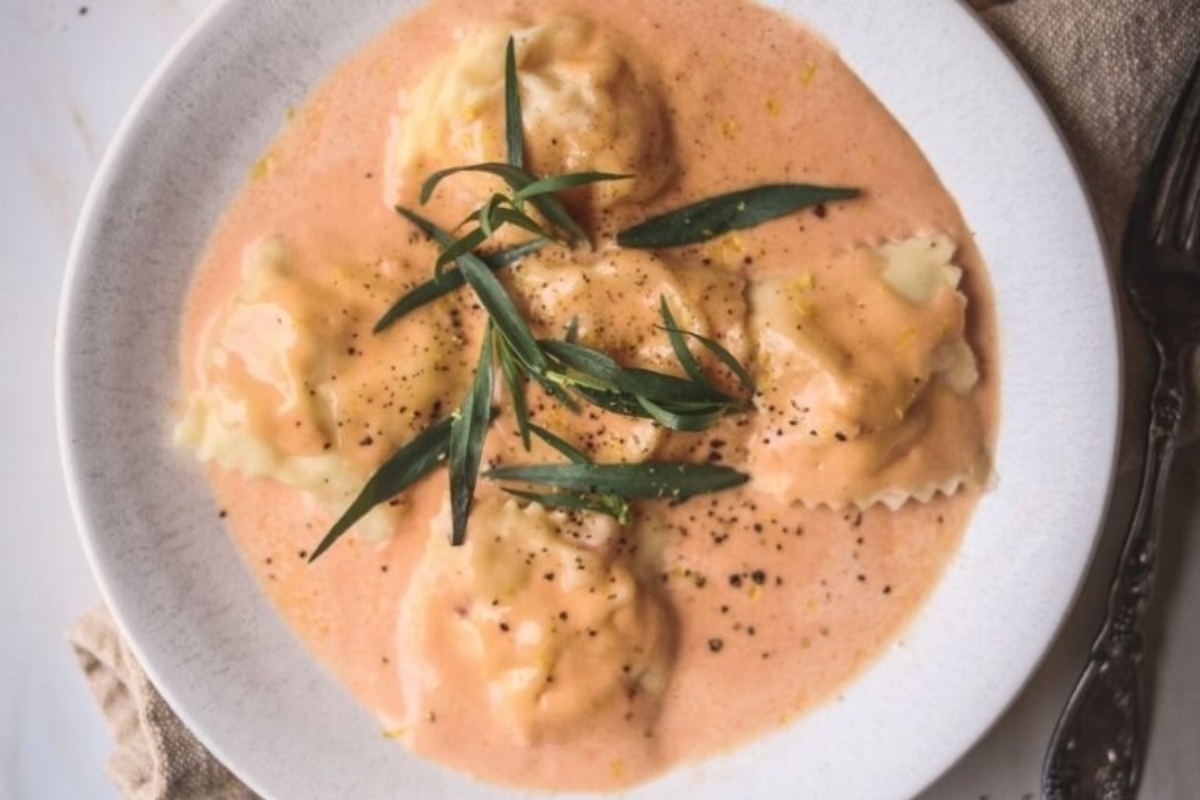 A plate of ravioli with sauce and sprigs of sage, perfect for a Feast.