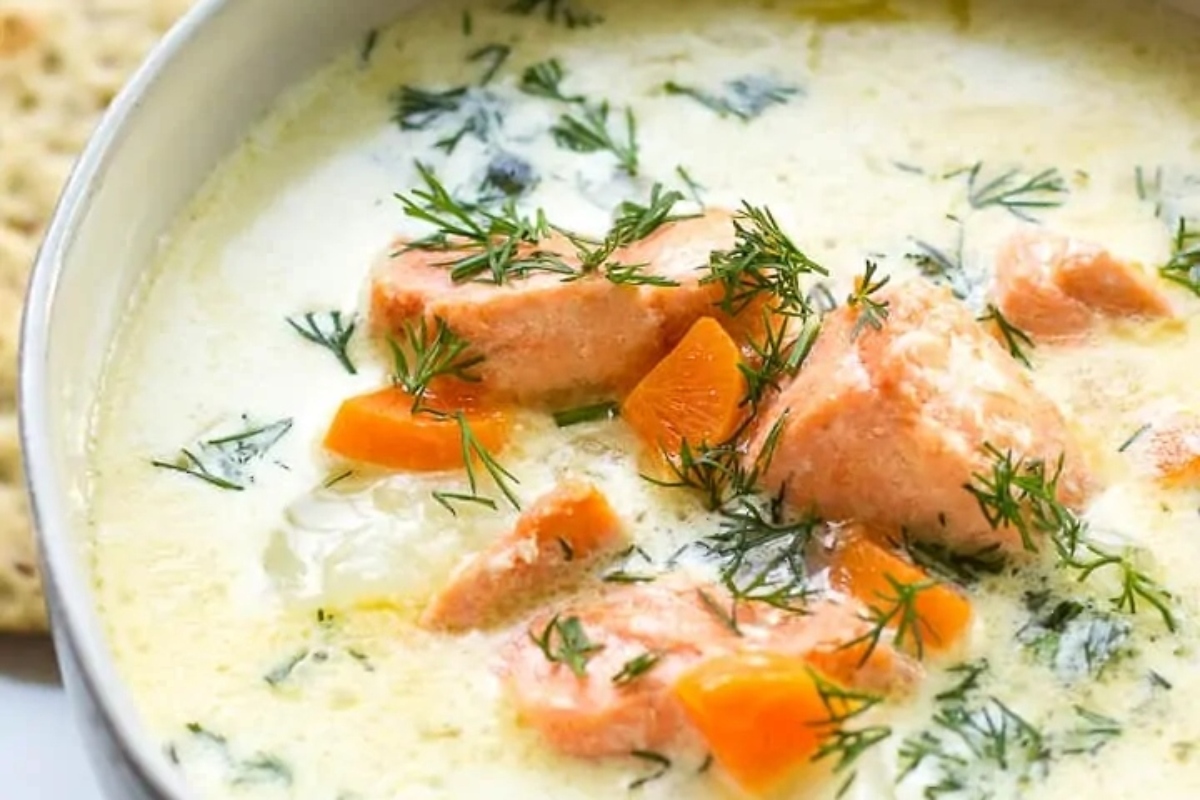 Salmon soup in a bowl with crackers.
