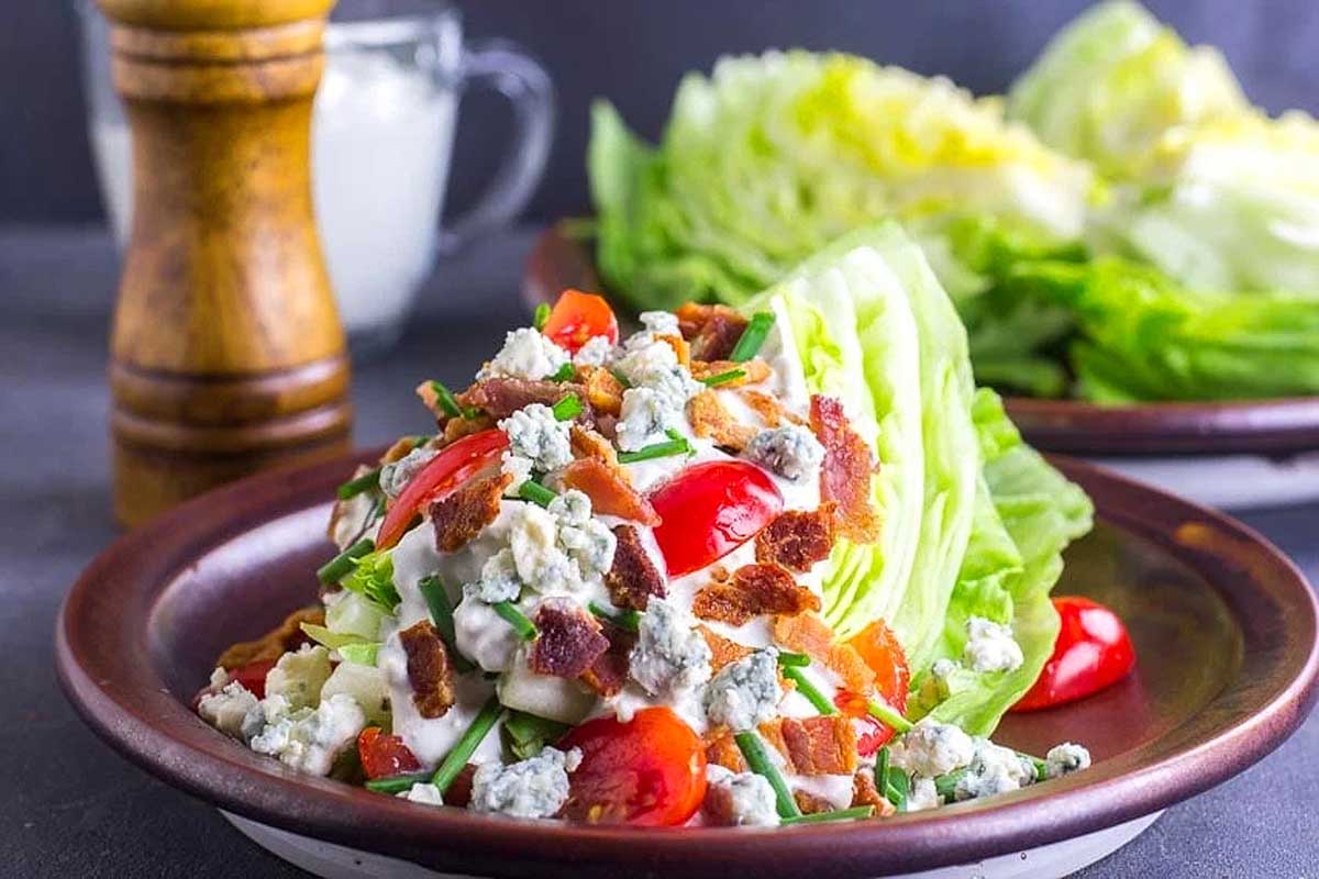 A bowl of lettuce salad with blue cheese dressing.