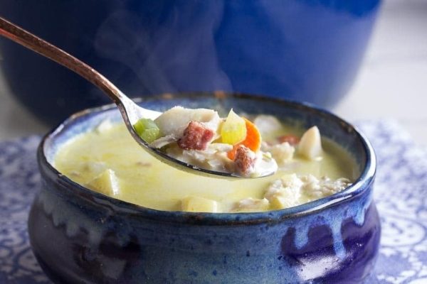 A spoonful of soup in a blue bowl.