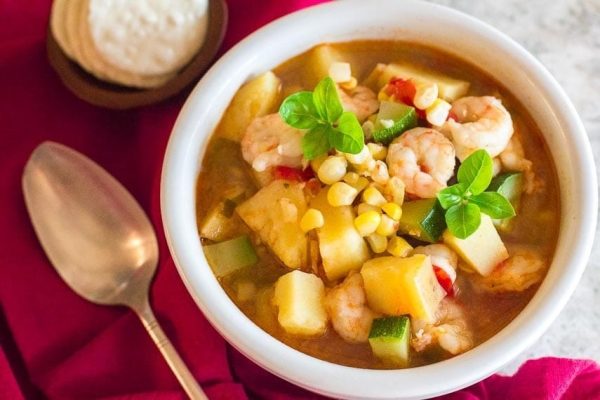 A classic shrimp and potato soup recipe, served with a spoon.