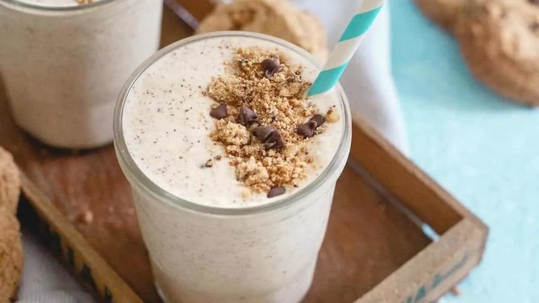 Two glasses of chocolate chip cookie smoothie milkshake on a tray.