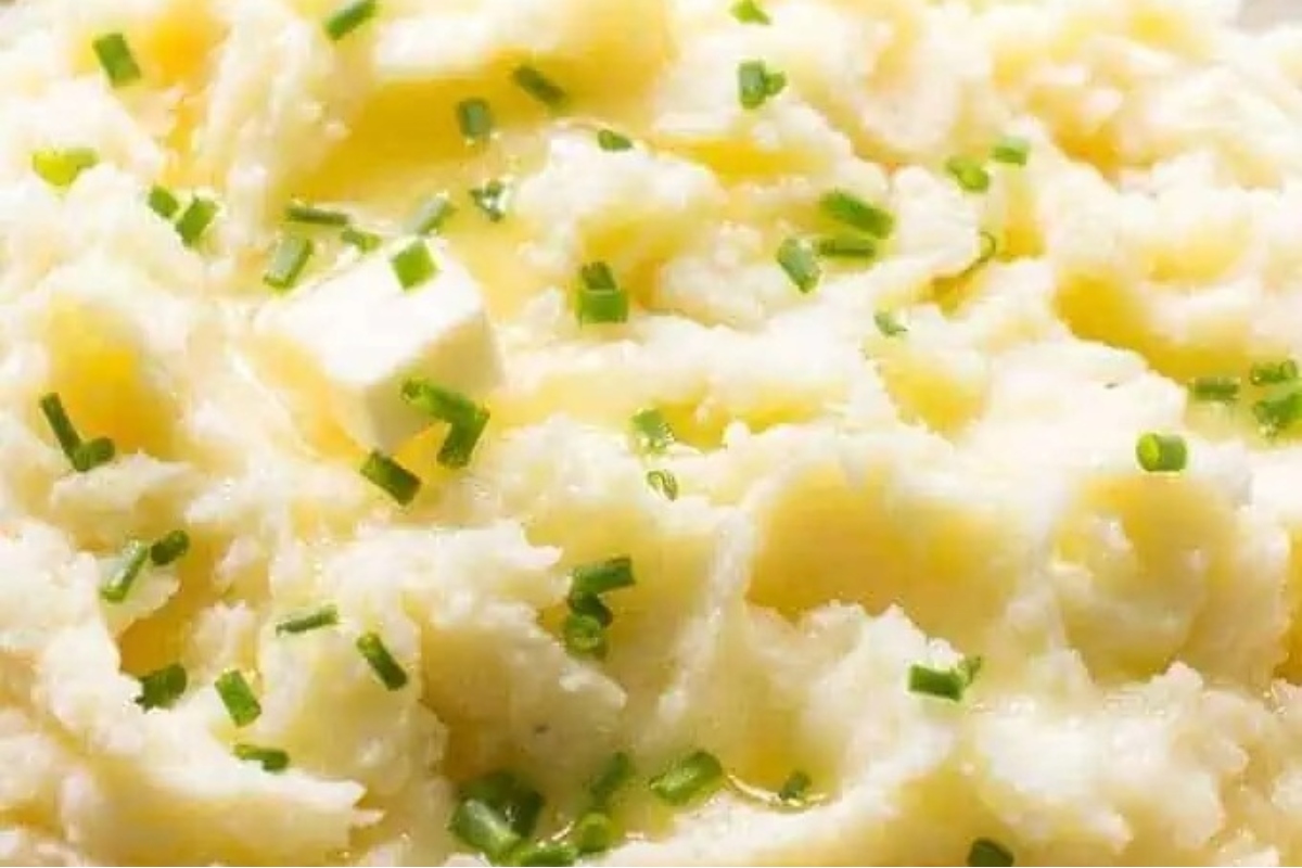 A close up of mashed potatoes garnished with chives.