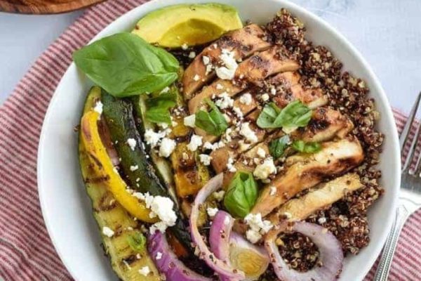 A bowl with chicken, vegetables and quinoa.