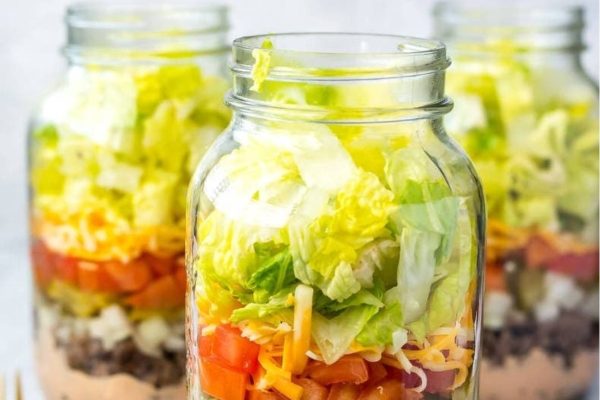 A mason jar with a salad in it, perfect for meal prep lunches.