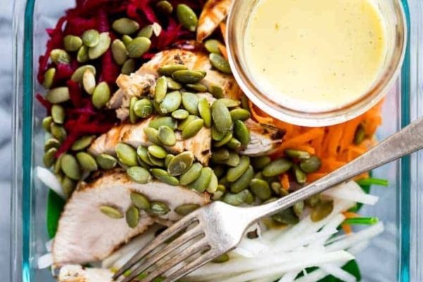 Chicken salad in a clear container with a fork.