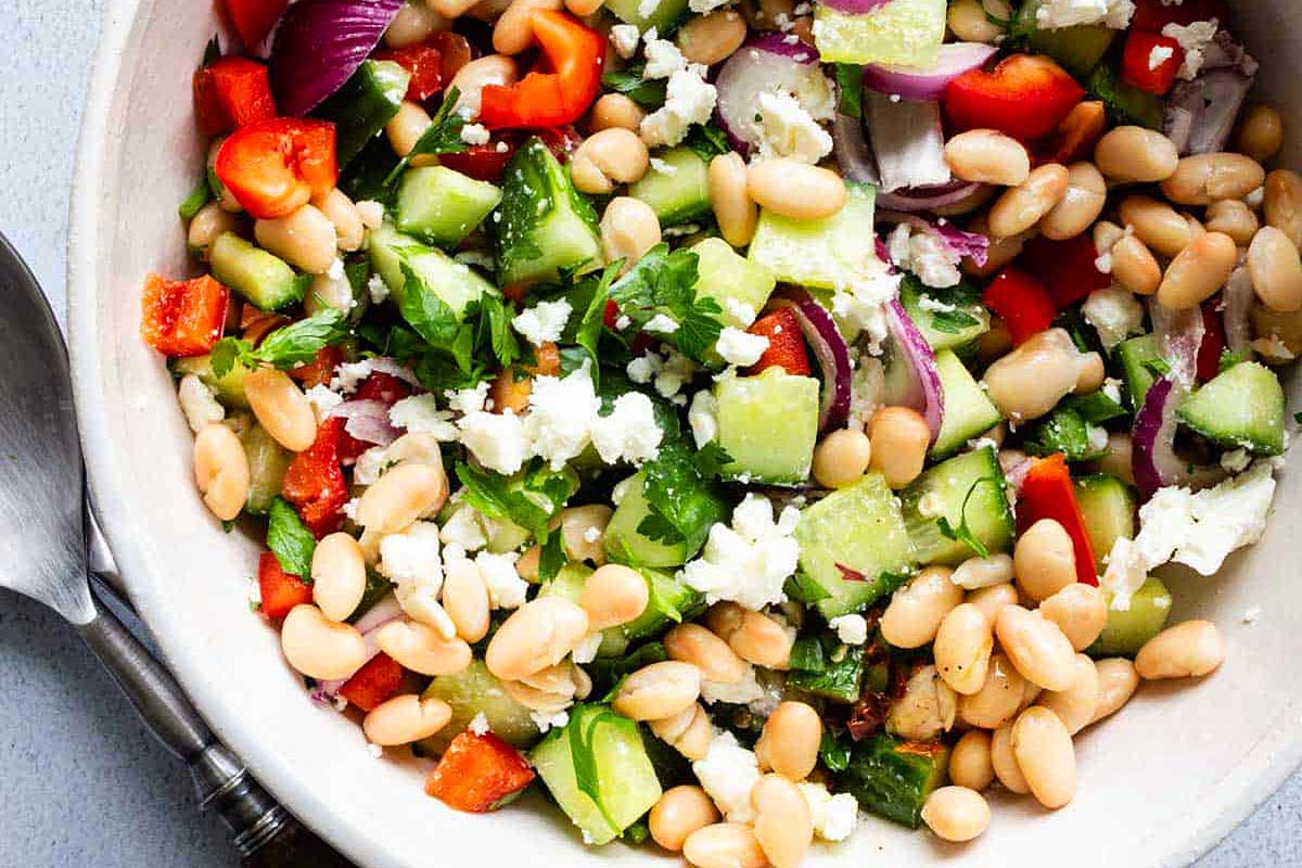White bean salad in a white bowl.