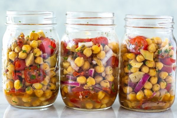 Three mason jars filled with meal prep lunches containing chickpeas and tomatoes.