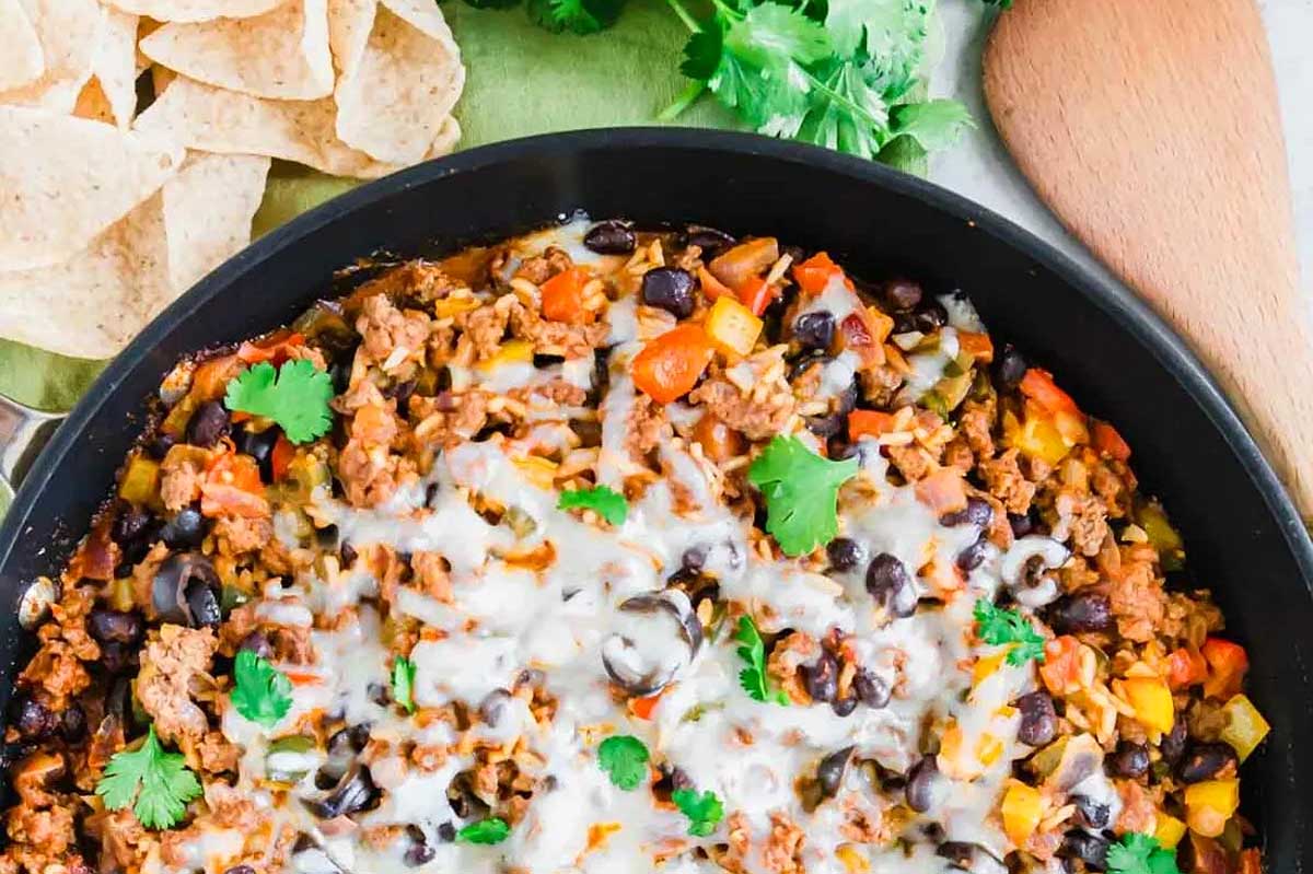 Mexican dip in a skillet with tortilla chips.