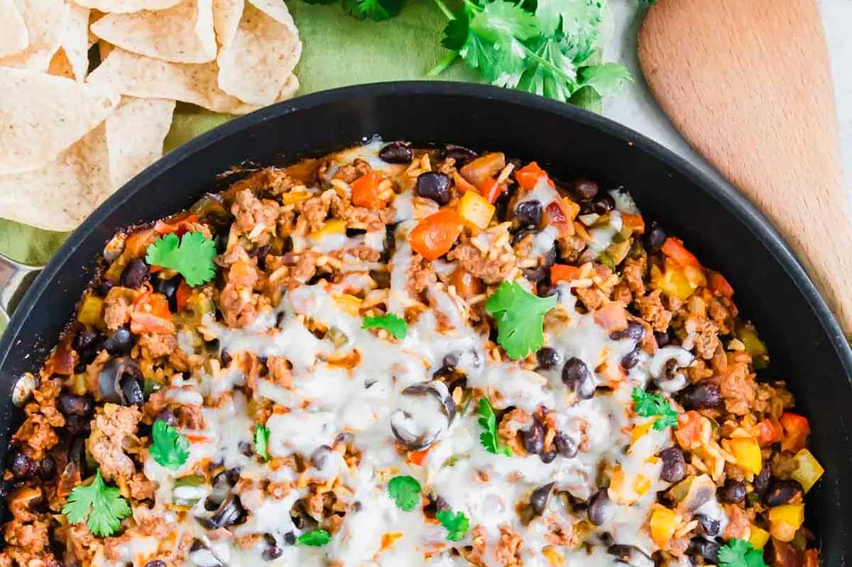 Mexican dip in a skillet with tortilla chips.