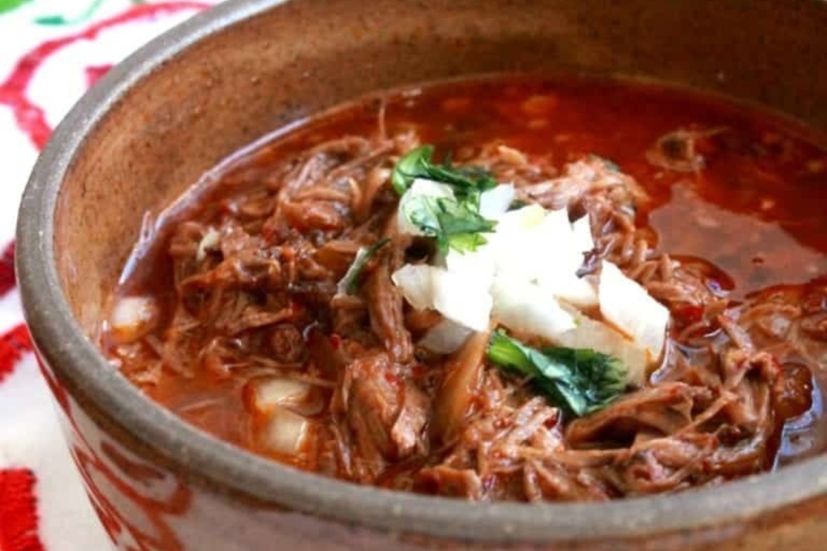 A delicious bowl of Mexican beef stew, cooked to perfection in a slow cooker, placed enticingly on a table.