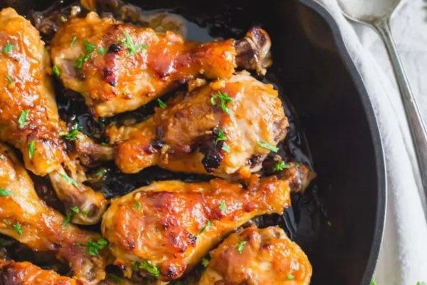 Chicken legs in a skillet with parsley.