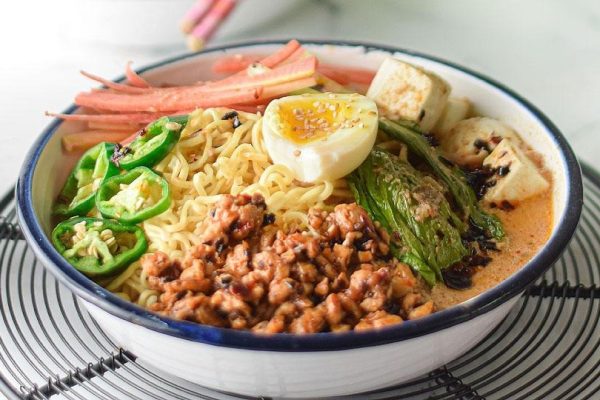 A flavorful bowl of ramen noodles with tender meat and fresh vegetables.