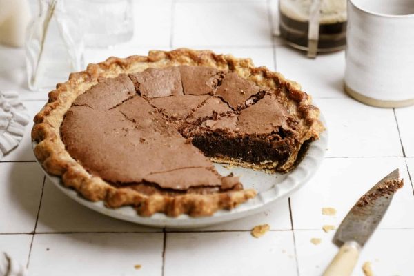 A chocolate pie with a slice taken out.