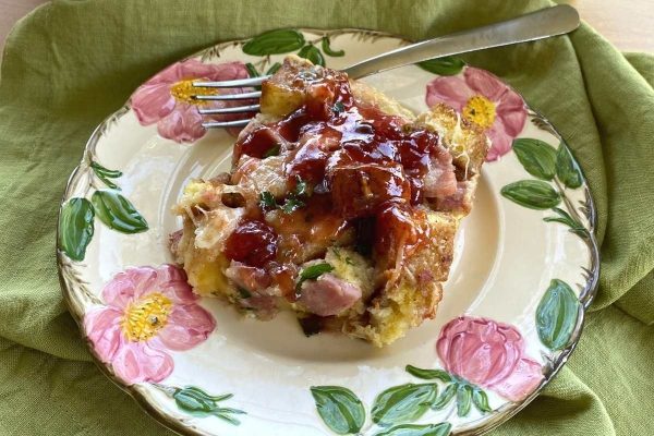 A plate of ham and cheese casserole with a fork.