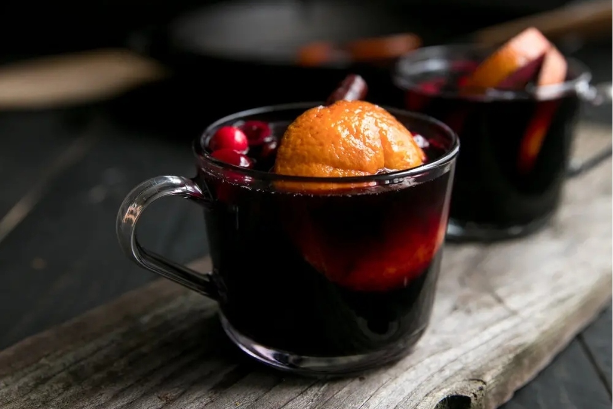 Two glasses of mulled wine sitting on a wooden table, perfect for Thanksgiving festivities.