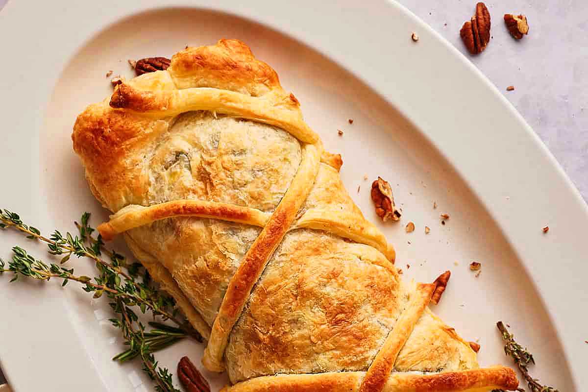 A plate with a stuffed pastry with a sprig of thyme.