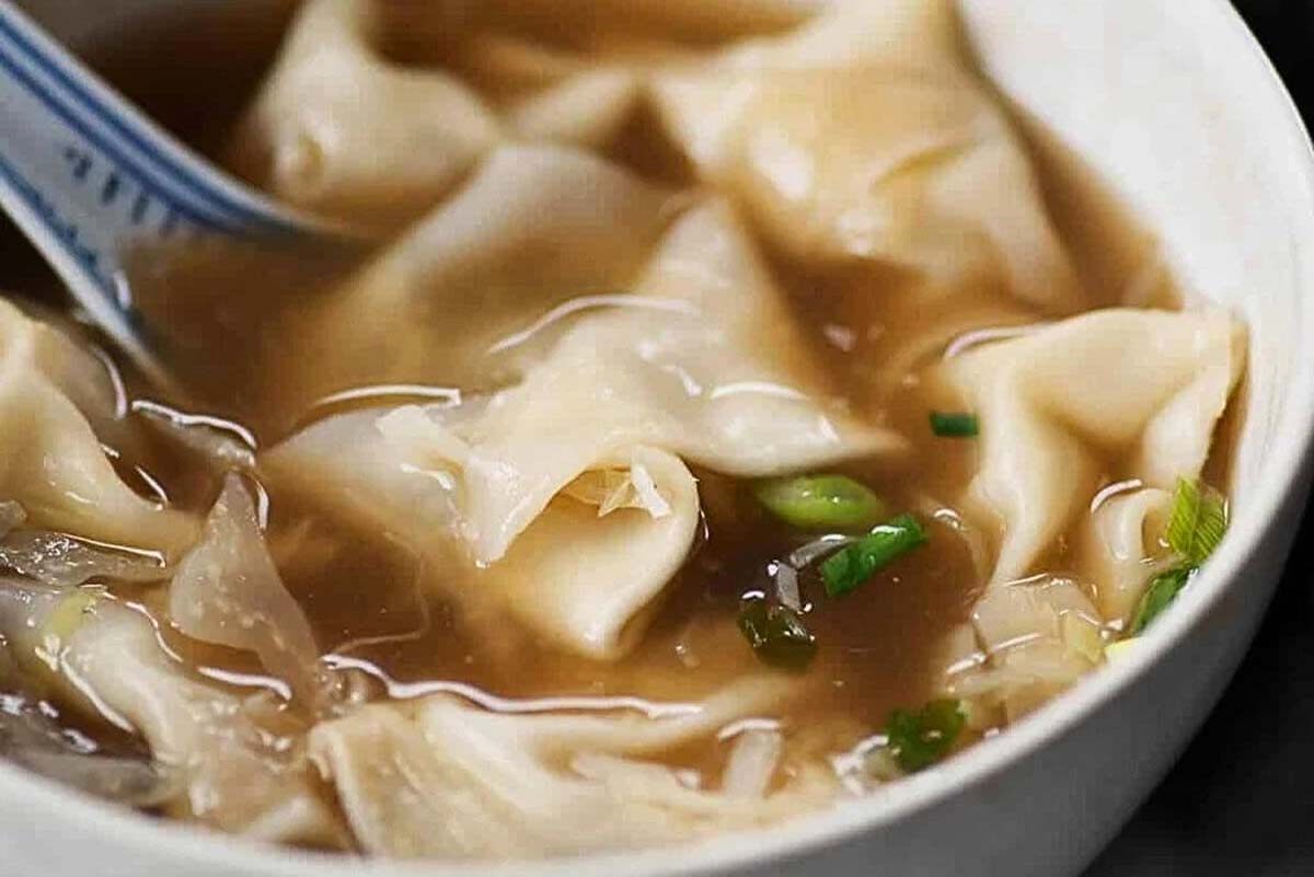 An amazing bowl of soup with delicious dumplings in it.