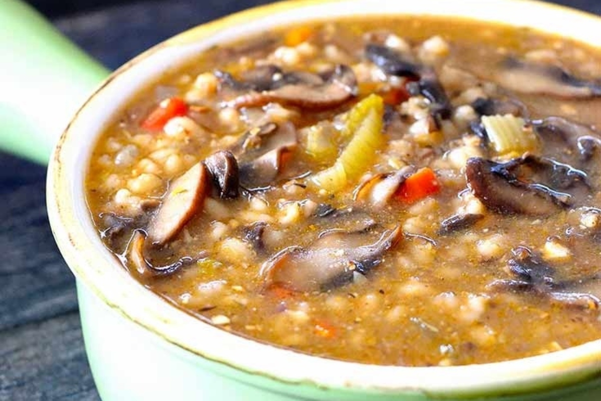 A delicious mushroom soup recipe on a rustic wooden table.