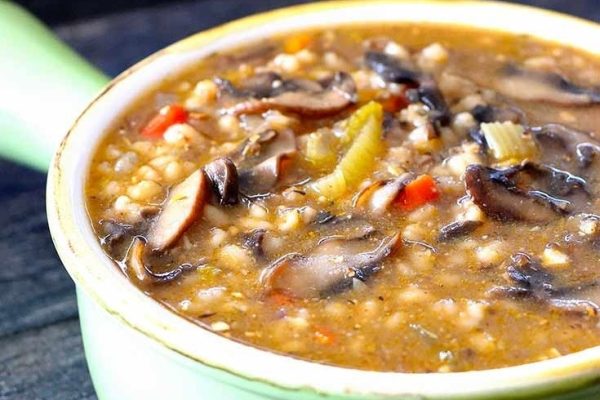 Mushroom and barley soup in a green bowl.