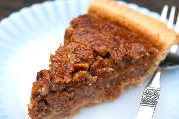 A traditional slice of pecan pie on a plate.