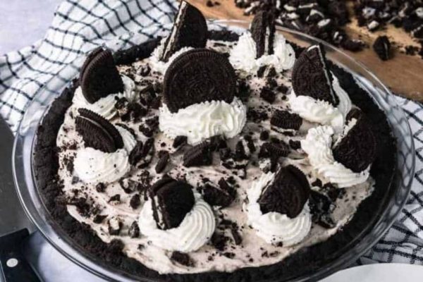 Oreo pie in a glass bowl with whipped cream and oreos.