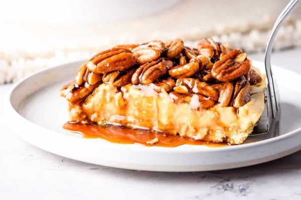 A slice of pecan pie on a plate with a fork.