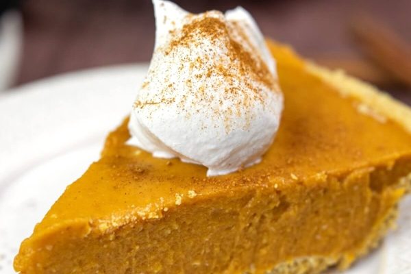 A slice of pumpkin pie on a plate.
