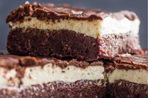 A stack of brownies with cream cheese frosting, perfect for dessert.