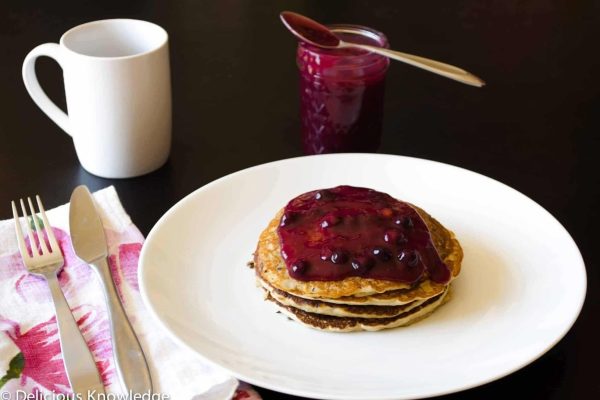 Pancakes with blueberry sauce on a plate.